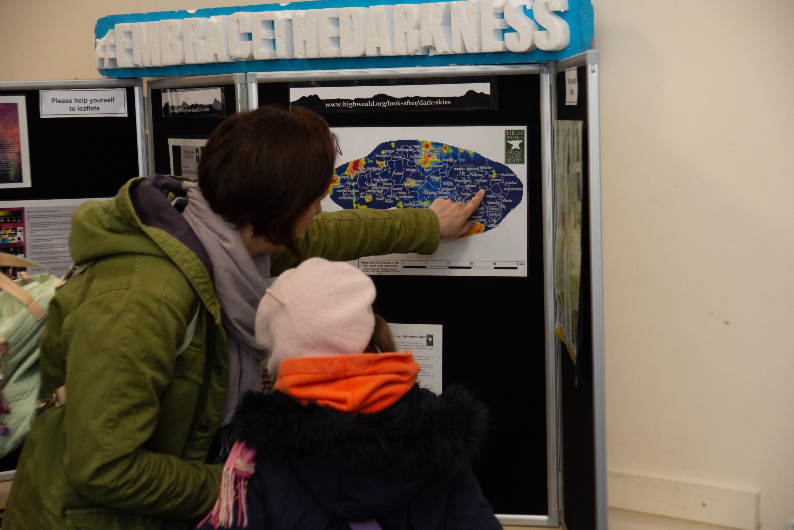 a mother and daughter looking at a display board