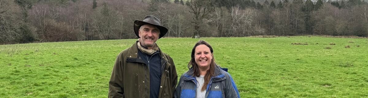 A man and woman standing in a field